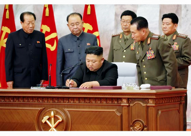 북한은 김정은 국무위원장이 주재한 가운데 당 중앙군사위원회 제7기 제4차 확대회의를 열었다고 북한매체들이 24일 보도했다. 이번 회의에서는 당 중앙군사위 인사도 단행됐다. 승진 인사 대상인 최부일, 리병철, 김수길, 박정천, 정경택(왼쪽부터)이 문서에 서명하는 김정은 위원장을 보고 있다. 연합뉴스