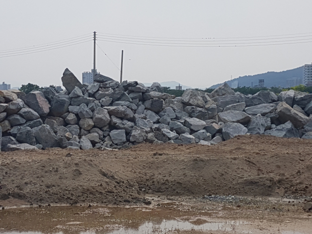 불법성토된 문경시 영순면 포내리 농경지 한켠에는 산 절개공사와 도로개설 공사현장에서 반출된 것으로 추정되는 발파석 등이 산더미 처럼 쌓여 있다.고도현 기자