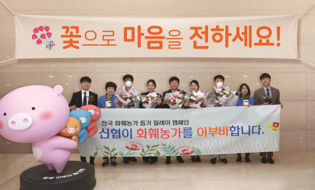 김윤식 회장이 화훼농가 돕기 릴레이 캠페인에 참여하고, 직원들에게 꽃 화분 및 전통시장상품권을 전달하고 있다. 신협중앙회 제공