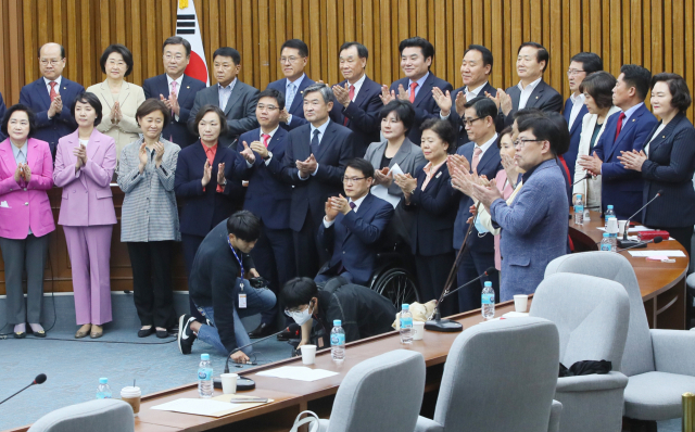 미래한국당 원유철 대표, 국회의원, 당선인들이 26일 국회에서 열린 합동연석회의를 마친 뒤 미래통합당과 합당 결의문을 발표하고 있다. 연합뉴스