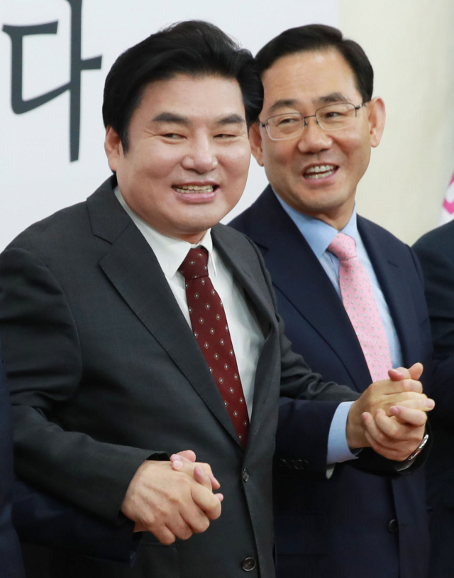미래통합당 주호영 원내대표와 미래한국당 원유철 대표가 28일 오전 서울 여의도 국회에서 열린 미래통합당-미래한국당 합당 선포식에서 손을 잡고 있다. 연합뉴스
