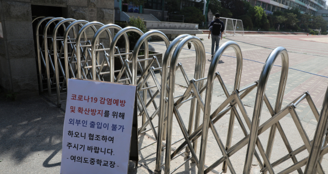 29일 오전 여의도중학교에서 관계자가 학교 정문으로 들어가고 있다. 이 학교는 여의도 학원강사와 수강생 코로나19 확진으로 이날 예정된 학생 등교를 온라인 수업으로 변경했다. 연합뉴스