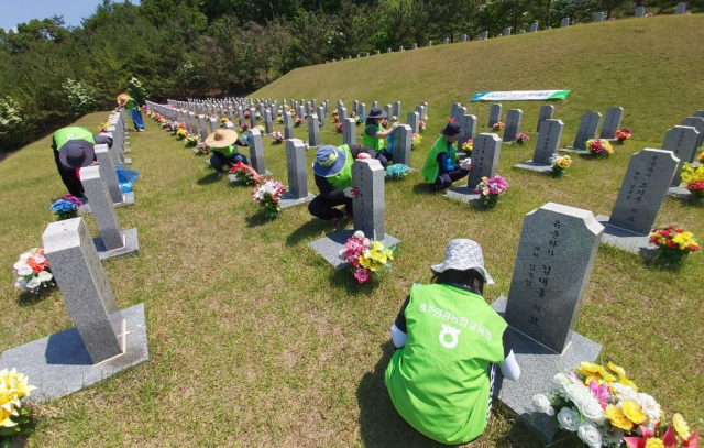 농협경주환경농업교육원 교직원들이 국립영천호국원에서 유공자 묘역 정비 봉사활동을 펼치고 있다. 농협경주환경농업교육원 제공