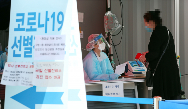 1일 오전 서울 영등포구 보건소에 마련된 코로나19 선별진료소에서 의료진이 시민들의 진료 접수를 돕고 있다. 연합뉴스