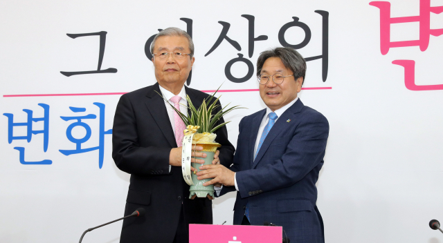 미래통합당 김종인 비상대책위원장(왼쪽)이 2일 오후 서울 여의도 국회에서 강기정 청와대 정무수석의 예방을 받고 문재인 대통령의 취임 축하 난을 전달받고 있다. 연합뉴스