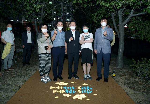 최기문(가운데) 영천시장과 영천시 담당업무 관계자들이 망정우로지 명소화사업 현장 점검 도중 만난 시민들과 사진촬영을 하고 있다. 영천시 제공