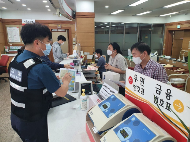 경산경찰서 소속 경찰관이 우체국에서 직원을 대상으로 전화금융사기 예방 홍보활동을 하고 있다. 경산경찰서 제공