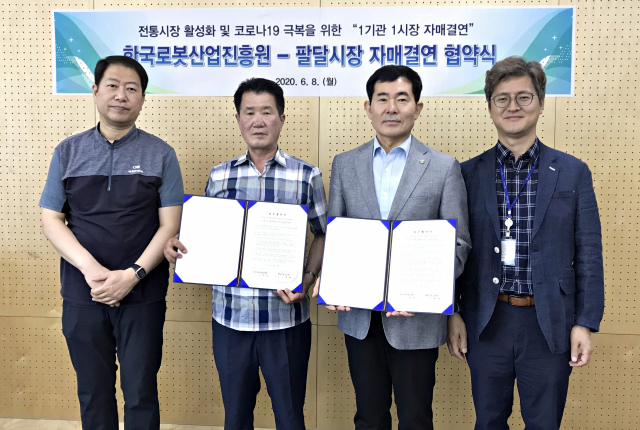 문전일(오른쪽 두 번째) 로봇산업진흥원장과 김헌태(왼쪽 두 번째) 팔달시장 상인회장이 8일 자매결연 협약식을 맺었다. 한국로봇산업진흥원 제공