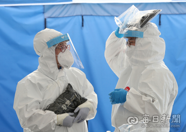 대구 낮 최고기온이 37℃ 까지 올라 불볕더위가 이어진 지난 9일 오후 수성구보건소 선별진료소에서 방호복을 입은 의료진이 코로나19 의심환자가 뜸해진 시간에 아이스팩으로 잠시 열기를 식히고 있다. 성일권 기자 sungig@imaeil.com