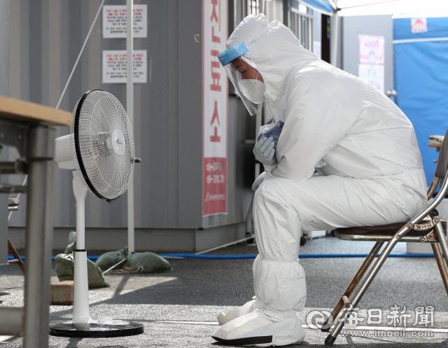 대구 낮 최고기온이 37℃ 까지 올라 불볕더위가 이어진 9일 오후 수성구보건소 선별진료소에서 방호복을 입은 의료진이 코로나19 의심환자가 뜸해진 시간에 선풍기와 아이스팩으로 열기를 식히고 있다. 성일권 기자 sungig@imaeil.com