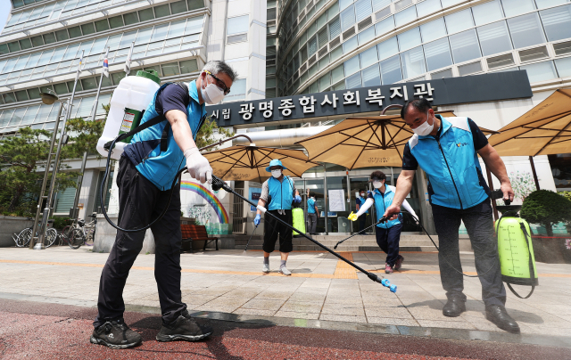 입소자 3명과 종사자 3명이 전날 밤 신종 코로나바이러스 감염증(코로나19) 확진 판정을 받은 경기도 광명시 광명어르신보호센터가 입주한 광명종합사회복지관 앞에서 9일 오후 광명3동자율방재단원들이 주변 방역을 하고 있다. 연합뉴스