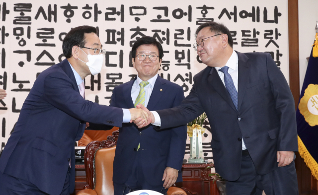 더불어민주당 김태년 원내대표(오른쪽)와 미래통합당 주호영 원내대표(왼쪽)가 이 11일 오전 서울 여의도 국회 국회의장실에서 열린 21대 국회 전반기 원구성 협상을 위한 국회의장 주재 원내대표 회동에서 악수하고 있다. 가운데는 박병석 국회의장. 연합뉴스