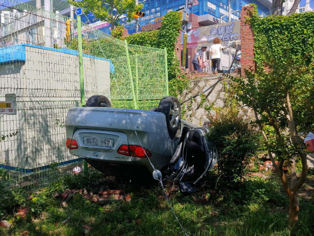 15일 오후 3시 30분께 부산 해운대구 재송동 한 초등학교 스쿨존에서 아반떼 승용차가 인도 위 30대 여성과 6세 딸을 덮친 뒤 인근 벽을 부수고 추락한 현장. 이 사고로 6세 여아가 중태이며 엄마도 다쳐 병원에서 치료를 받고 있다. 연합뉴스