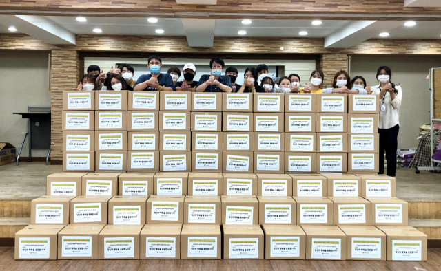 구미종합사회복지관 직원들이 지역 소상공인들에게 전달한 생필품 세트와 함께 기념촬영을 하고 있다. 구미시 제공