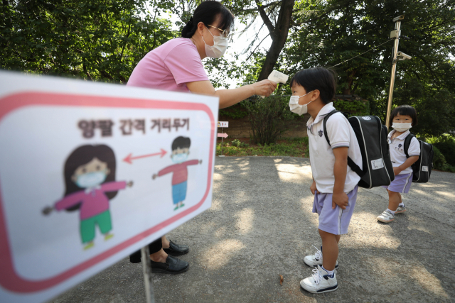 대구지역 어린이집이 신종 코로나바이러스 감염증(코로나19) 사태로 휴원 후 122일 만에 정상 등원을 시작한 지난 22일 오전. 대구시 중구 대구 백합어린이집에서 어린이들이 거리 두기를 실천하며 교실로 가기전 발열체크를 하고 있다. 연합뉴스
