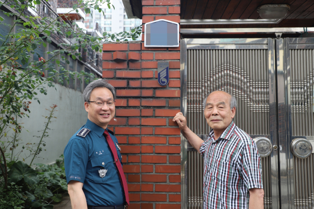 정상진 대구 수성경찰서장(왼쪽)과 월남전 참전용사 김종준 씨가 국가유공자 명패 앞에서 웃어보이고 있다. 수성경찰서 제공