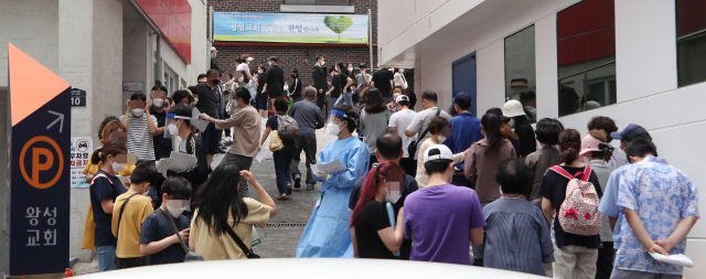 26일 신종 코로나바이러스 감염증(코로나19) 확진자가 발생한 서울 관악구 왕성교회에 설치된 임시 선별진료소에서 교인들이 검체 채취를 받기 위해 길게 줄지어 서 있다. 연합뉴스