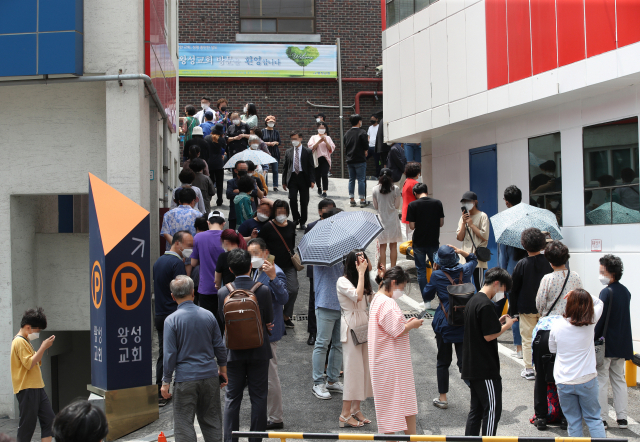 26일 신종 코로나바이러스 감염증(코로나19) 확진자가 발생한 서울 관악구 왕성교회에 설치된 임시 선별진료소에서 교인들이 검체 채취를 받기 위해 줄지어 서 있다. 연합뉴스