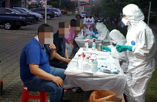 충북 옥천군 보건소 역학조사관들이 28일 이원면 보건지소 앞 광장에 차려진 선별진료소에서 주민들을 대상으로 역학조사를 하고 있다. 이 지역에서는 전날 코로나19 확진자가 발생했다. 연합뉴스