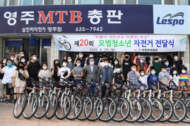 따뜻한마음회 회원들이 모범청소년들에게 자전거를 전달하고 있다. 영주시 제공