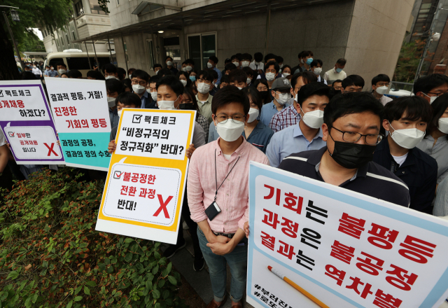 인천국제공항공사노동조합 소속 조합원들이 25일 오후 서울 청와대 인근에서 열린 기자회견에서 비정규직 보안검색 요원들의 정규직 전환 관련 입장을 발표하며 손팻말을 들고 있다. 연합뉴스