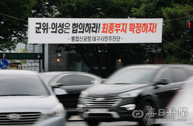 대구경북 통합신공항 이전사업이 지자체 간의 갈등으로 중대한 고비를 맞고 있다. 29일 동구 불로삼거리에 군위와 의성의 합의를 촉구하는 현수막이 걸려 있다. 우태욱 기자 woo@imaeil.com