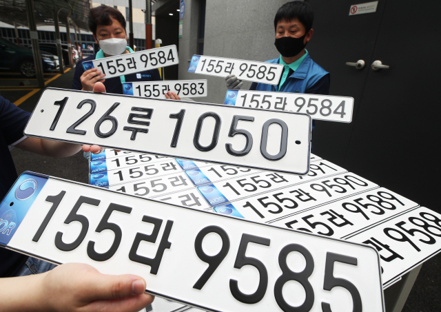 지난 6월 29일 수원도시공사 번호판제작소 관계자들이 7월부터 도입되는 반사필름식 번호판을 살펴보고 있다. 연합뉴스