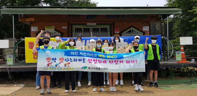 대구 북구자원봉사센터가 27일 침산교 자전거 수리센터 앞에서 야간 자전거 사고를 방지하고 자전거 안전수칙을 알리기 위한 