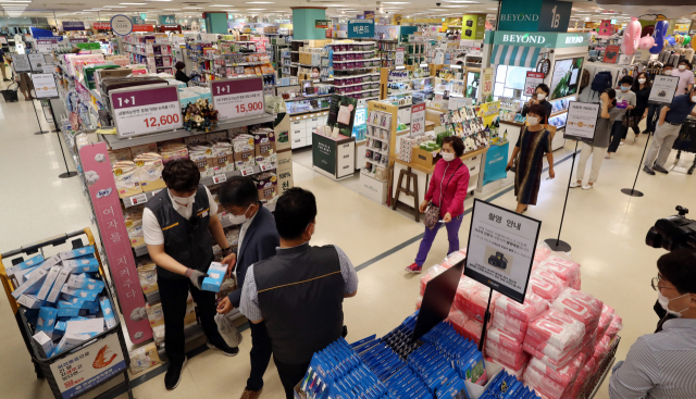 지난 24일 오후 서울 성동구 이마트 성수점에서 시민들이 비말 차단용 마스크를 구매하고 있다. 이마트는 이날 미리 배부한 번호표를 소지한 고객에게 장당 500원에 마스크 판매를 시작했으며 1인당 1상자(20장)만 구매할 수 있다. 연합뉴스