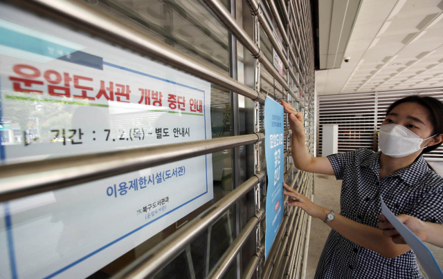 2일 오전 광주 북구 운암도서관에서 직원들이 최근 지역 내 코로나19 확산에 도서관이 휴관에 들어가게 돼 출입문에 안내문을 붙이고 있다. 광주시는 신종 코로나바이러스 감염증 지역사회 확산방지를 위해 방역지침을 사회적 거리두기 2단계로 격상시켰다. 연합뉴스