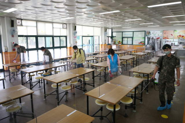 3일 오전 광주 북구 한 초등학교 급식실에서 운암1동 행정복지센터 관계자들이 오는 6일부터 재개되는 학생 등교 수업에 대비해 급식실을 소독하고 있다. 연합뉴스
