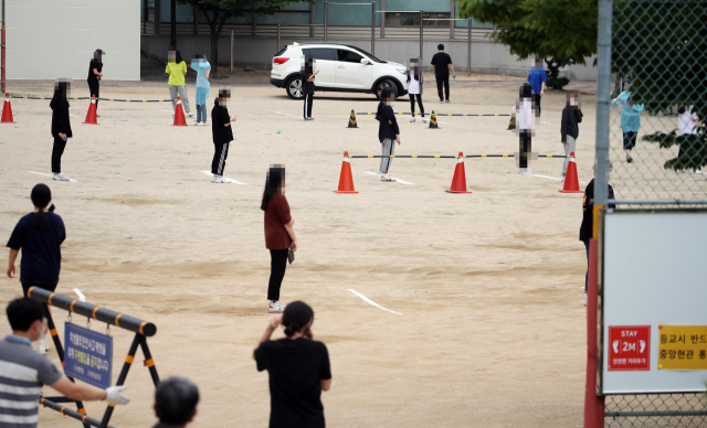 코로나19 확진자가 나온 대구 수성구 대구 남산고등학교 운동장에 지난 3일 선별진료소가 차려져 학생들이 코로나19 검사를 받고자 거리를 두고 서 있다. 연합뉴스