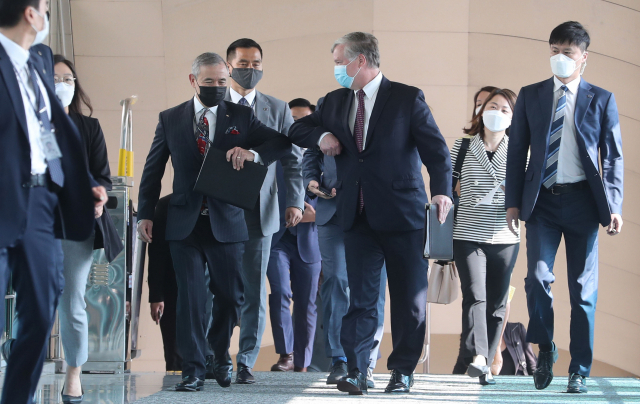 스티븐 비건 미국 국무부 부장관 겸 대북특별대표와 해리 해리스 주한미대사가 8일 오전 서울 종로구 정부서울청사에 도착해 외교부로 이동하던 중 팔꿈치를 부딪히고 있다. [사진공동취재단] 연합뉴스