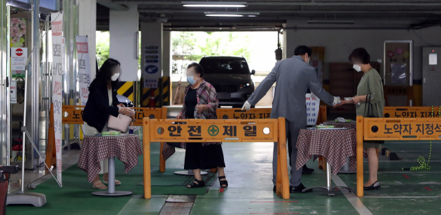 5일 오전 광주 북구 한 교회에서 관계자가 예배에 참석하려는 신도의 체온을 확인하고 있다. 광주시와 각 자치구는 신종 코로나바이러스 감염증(코로나19) 확산에 따른 사회적 거리두기 2단계 격상으로 종교시설 방역지침 준수 여부를 점검했다. 연합뉴스