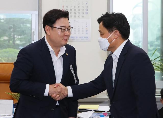 더불어민주당 김영진 원내총괄수석부대표(오른쪽)와 미래통합당 김성원 원내수석부대표가 13일 국회에서 만나 악수하고 있다. 연합뉴스