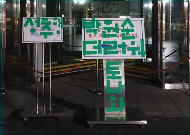 14일 오전 서울시청사 정문 앞에 설치된 안내 팻말 위에 고 박원순 서울시장을 비난하는 문구가 붙어있다. 커뮤니티 사이트 