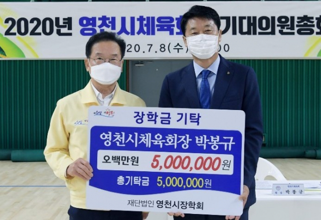 박봉규(오른쪽) 영천시체육회장이 최기문 영천시장에게 장학금 500만원을 전달하고 있다. 영천시체육회 제공