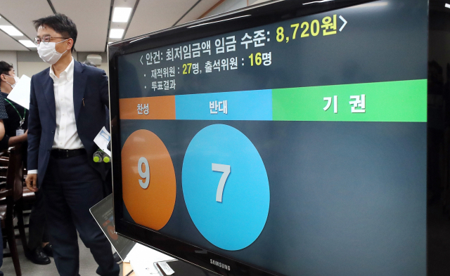 박준식 최저임금위원장(왼쪽)이 14일 새벽 세종시 정부세종청사 고용노동부에서 열린 제9차 최저임금위원회 전원회의 결과 브리핑을 마친 뒤 회의장을 나서고 있다. 이날 전원회의는 근로자위원들의 집단 퇴장으로 공익위원들이 낸 안으로 표결에 부쳐졌다. 찬성 9표, 반대 7표로 채택된 내년도 최저임금은 시급 기준 8천720원으로 최종 의결됐다. 연합뉴스
