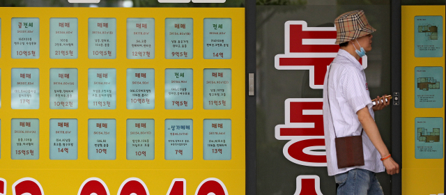 지난 9일 오후 한 시민이 대구 수성구의 한 부동산 중개사무소에 붙은 아파트 시세표 앞을 지나고 있다. 매일신문DB