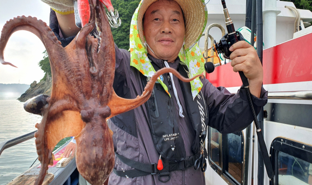 전남 광양에서 온 박오근씨가 잡아올린 돌문어를 들어보이고 있다.