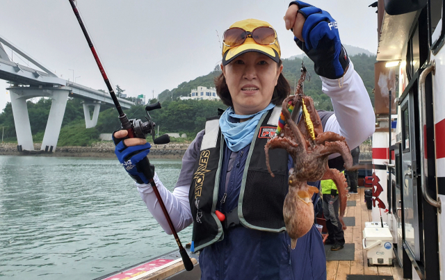 경기도 여주에서 남편을 따라 돌문어 낚시에 참가한 심재연씨가 돌문어를 들어보이고 있다.