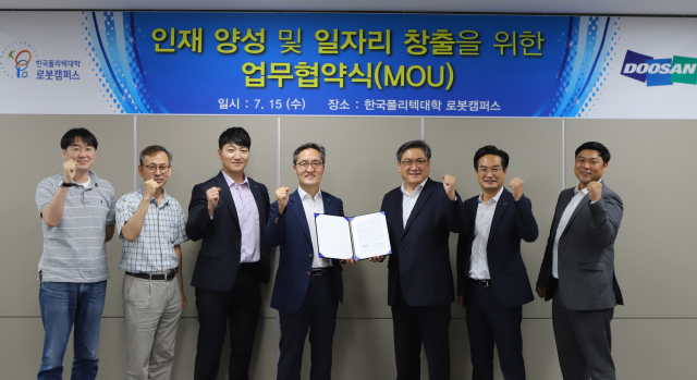 한국폴리텍대학 로봇캠퍼스 및 두산로보틱스 관계자들이 인재 양성 및 일자리 창출을 위한 업무협약(MOU) 체결 후 산학협력 결의를 다지고 있다. 한국폴리텍대학 로봇캠퍼스 제공