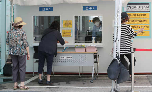 17일 오후 서울 강동구보건소에 마련된 선별진료소에서 시민들이 신종 코로나바이러스 감염증(코로나19) 검사를 받기 위해 의료진의 안내를 받고 있다. 연합뉴스