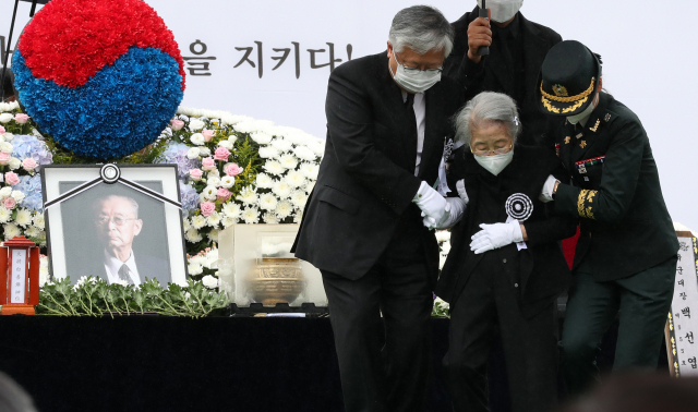 고 백선엽 예비역 육군 대장의 안장식이 엄수된 15일 오전 대전 유성구 국립대전현충원에서 백 장군의 부인 노인숙 여사가 헌화를 마친 후 부축받고 있다. 연합뉴스
