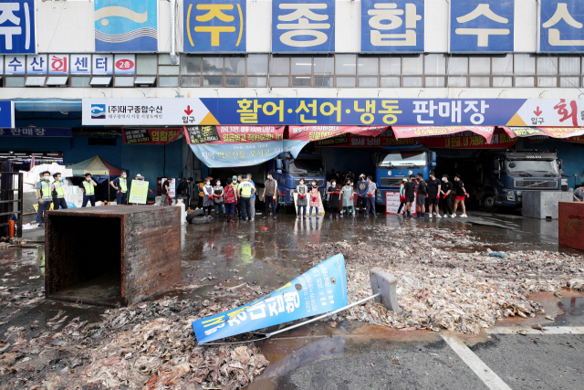 대구시가 20일 대구농수산물도매시장 내 수산동 일부에 대한 대집행에 들어가려 하자 상인들이 생선 찌꺼기를 주차장에 쏟아부으면서 강력하게 저항하고 있다. 김영진 기자 kyjmaeil@imaeil.com