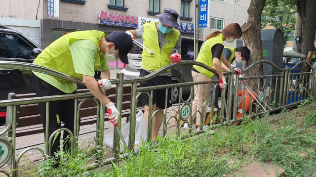 서울 서대문구 홍제천 일원에서 담배꽁초 등 생활쓰레기를 줍고 있는 지구시민운동연합 강북1지부 회원들.