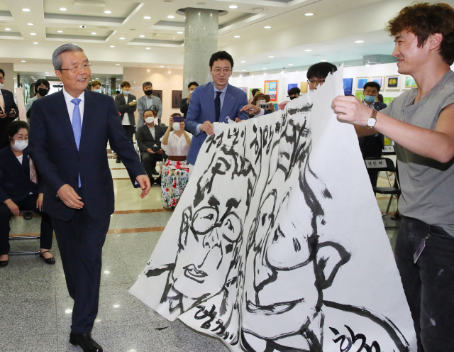 미래통합당 김종인 비상대책위원장(왼쪽)과 김웅 의원이 20일 국회 의원회관에서 열린 코로나19 예술인지원프로그램 플라잉 어게인 전에서 한상윤 작가(오른쪽)가 그린 본인들의 캐리커쳐를 보고 있다. 연합뉴스
