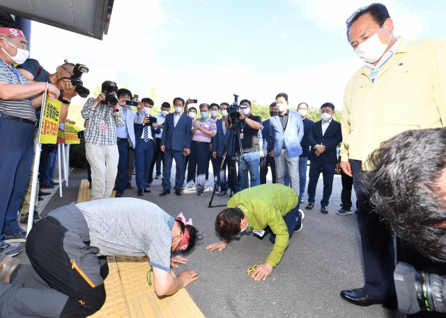 20일 대구·경북 통합신공항 부지 선정에 대승적 결단을 호소하기 위해 군위군청을 찾은 이철우 경북도지사가 단독후보지(군위 우보)를 주장하는 주민이 절을 하자 맞절을 하고 있다. 이 지사는 이날 권영진 대구시장과 함께 국방부가 공동후보지(의성 비안면·군위 소보면) 적합 여부 판단 시한으로 정한 31일까지 군위군이 공동후보지에 유치 신청을 하도록 촉구하는 호소문을 발표한 뒤 군위군청을 찾았다. 연합뉴스