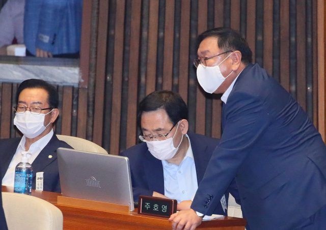 더불어민주당 김태년 원내대표(오른쪽)가 24일 국회 본회의장에서 미래통합당 주호영 원내대표를 찾아가 논의하고 있다. 연합뉴스