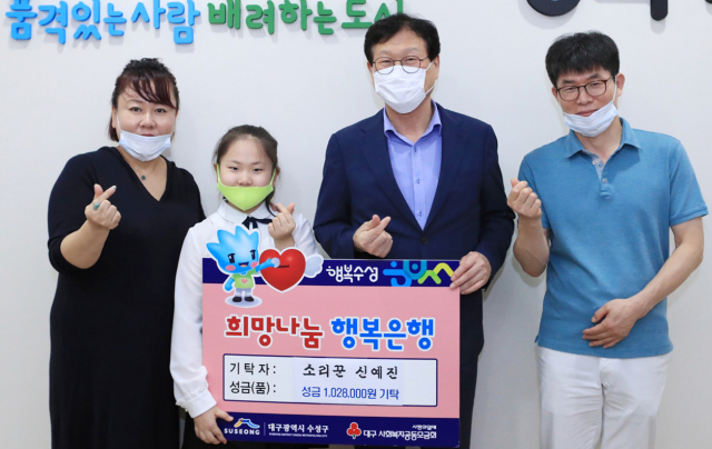 소리꾼 신예진(왼쪽에서 둘째) 학생이 저소득가정 아동을 위한 후원금을 전달하고 김대권(오른쪽에서 둘째) 수성구청장과 기념촬영을 하고 있다. 수성구청 제공